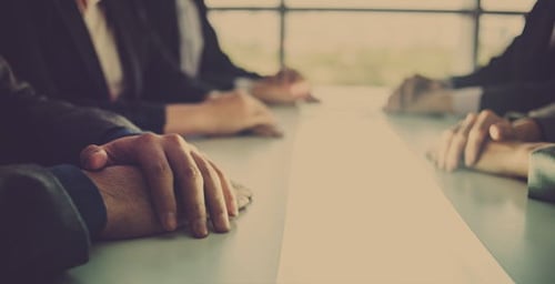 Folded hands on a table
